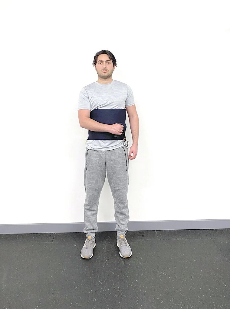 The user in the starting position for an external rotation exercise.