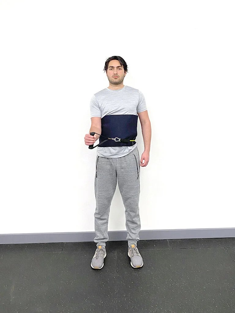 The user externally rotating the shoulder joint to complete the exercise.