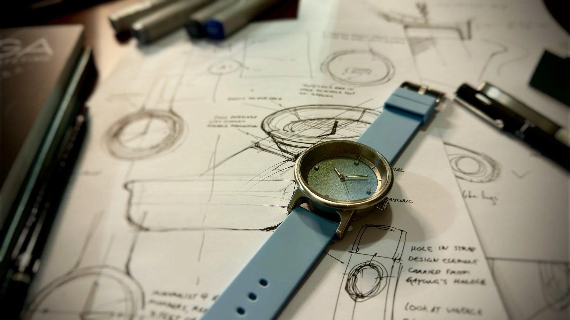 The watch laid on top of concept sketches