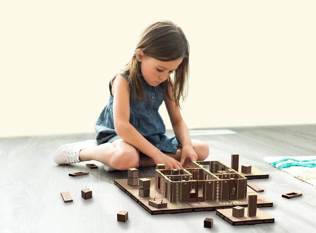 Child playing with The Energy House — LED pathways move as she moves blocks.